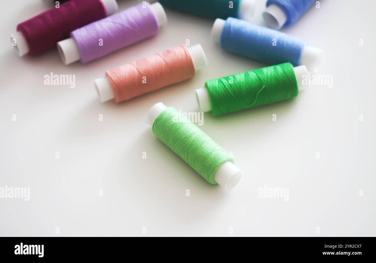 Many colorful sewing threads on light background. Stock Photo