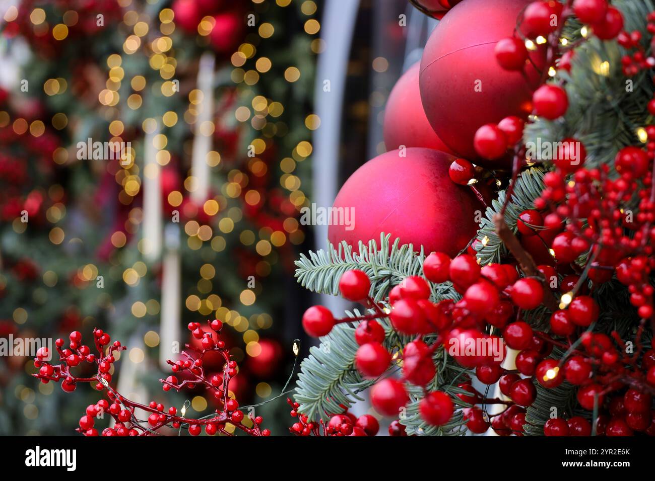New Year background, Christmas tree branches with red balls on blurred lights background Stock Photo