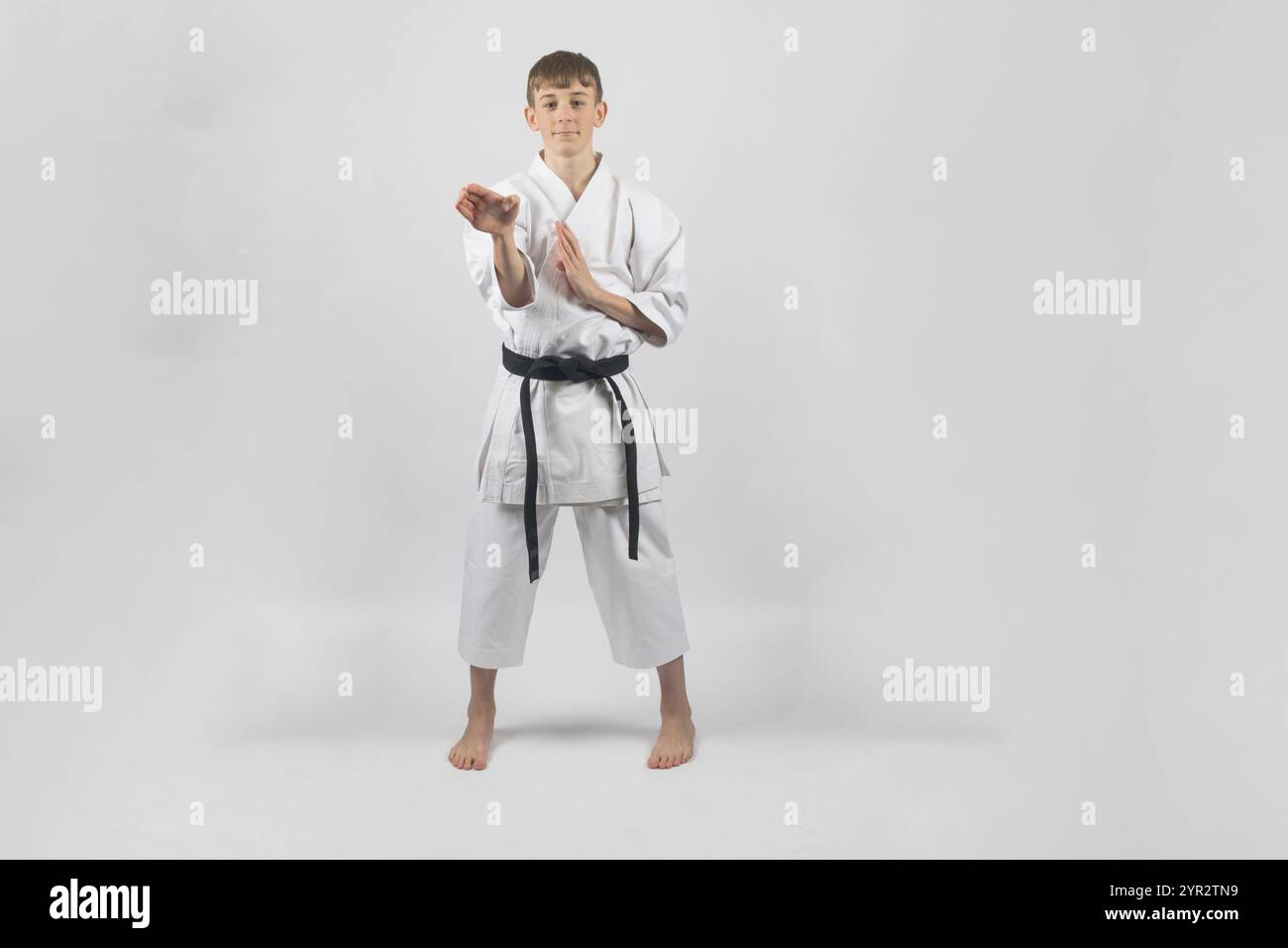 Fifteen year old male teenage karate black belt open hand block, studio ...