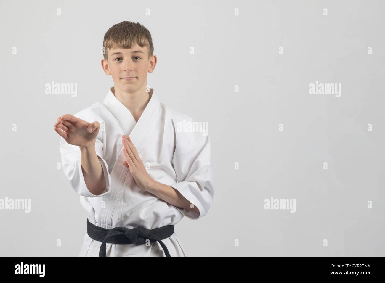 Fifteen year old male teenage karate black belt open hand block, studio ...