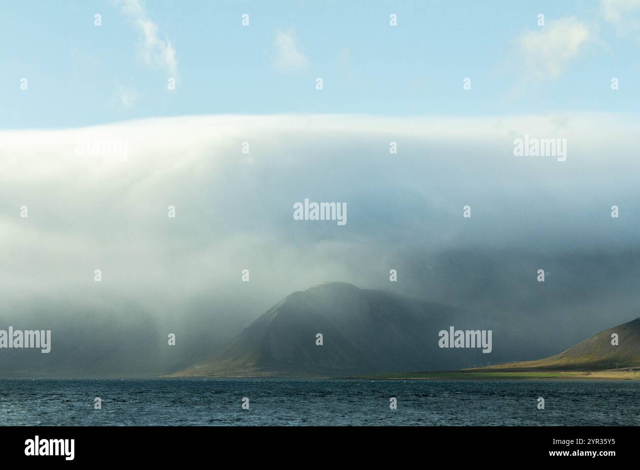 Icelandic mountains shrouded in clouds, creating a mystical atmosphere Stock Photo