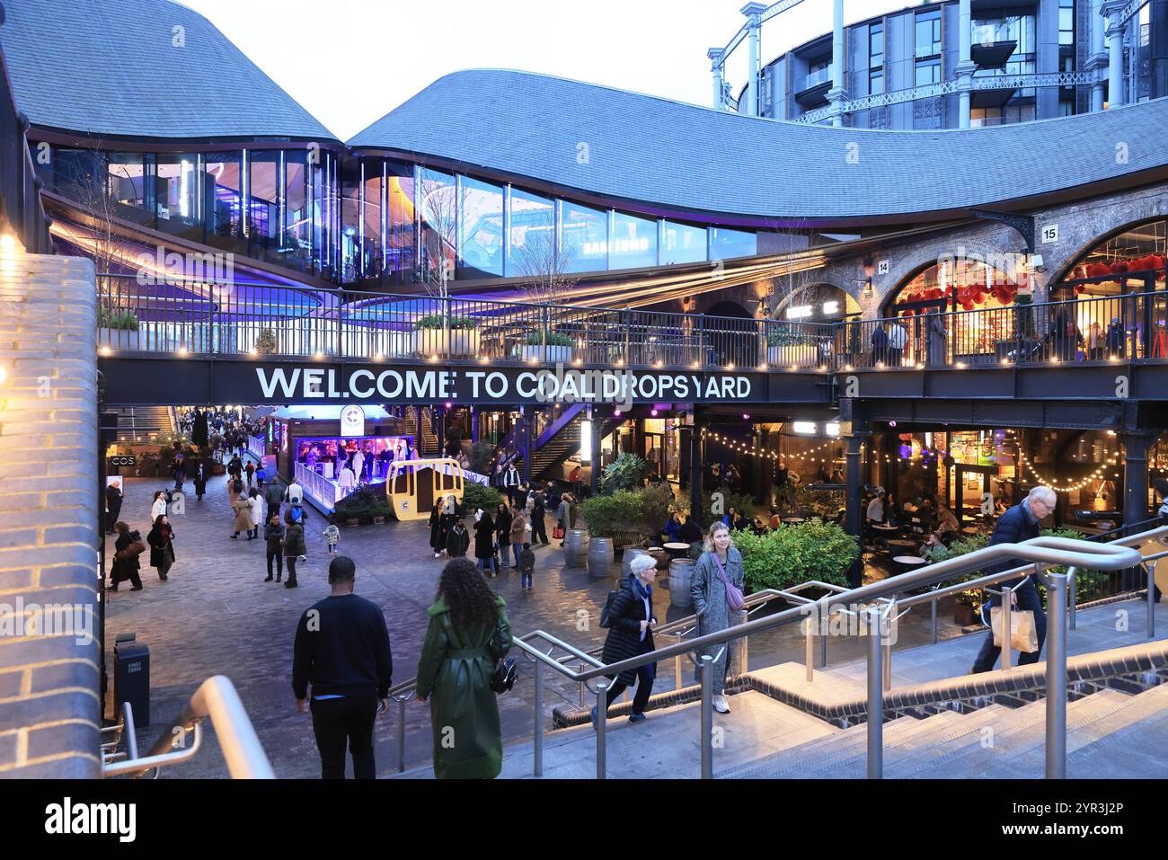 Coal Drops Yard at Christmas time, with shops and restaurants and the Gasholder apts beyond, at Kings Cross, north London, UK Stock Photo