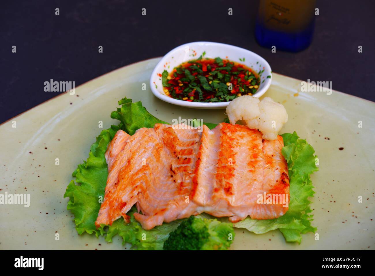 Salmon fish steak served with teriyaki sauce on a plate Stock Photo