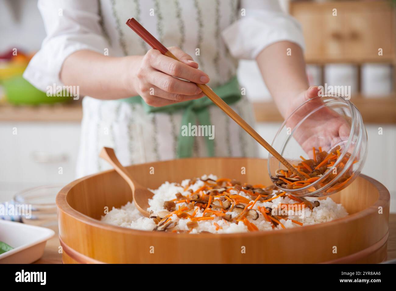 Women making chirashi-zushi by mixing ingredients with vinegared rice ...