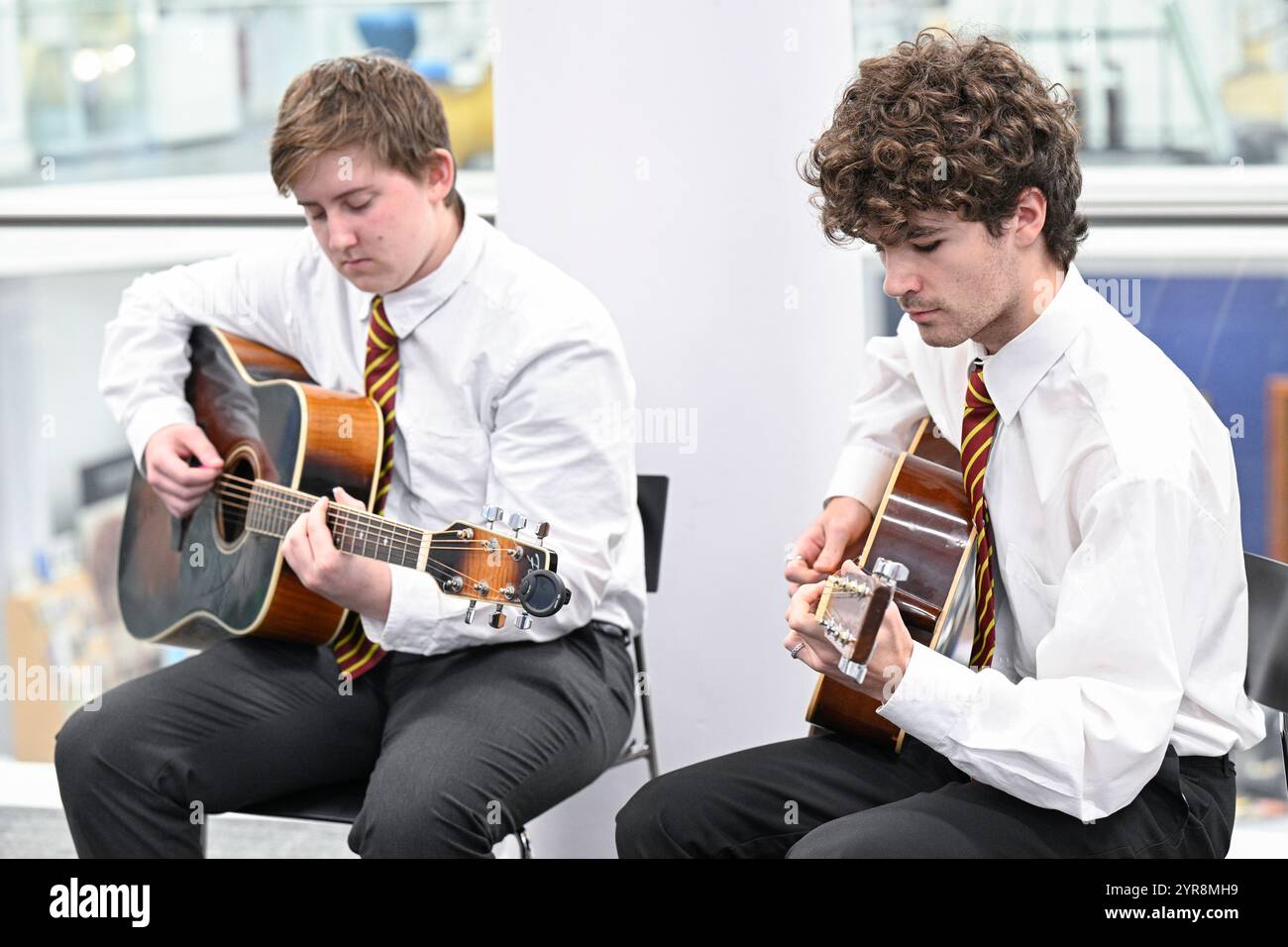 First Minister John Swinney listens to the guitar played by Flynn Conroy and Oscar Phillips from James Gillespie High School during a ceremony after Peter Mackay was announced as the new Makar (National Poet for Scotland). The position of Makar involves producing work relating to significant national events and taking a leadership role in promoting poetry nationally. Picture date: Monday December 2, 2024. Stock Photo