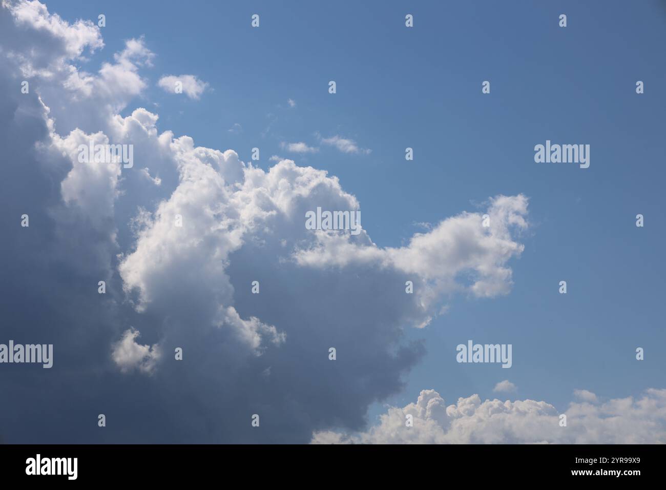 developing storm clouds against a clear deep blue sky Stock Photo