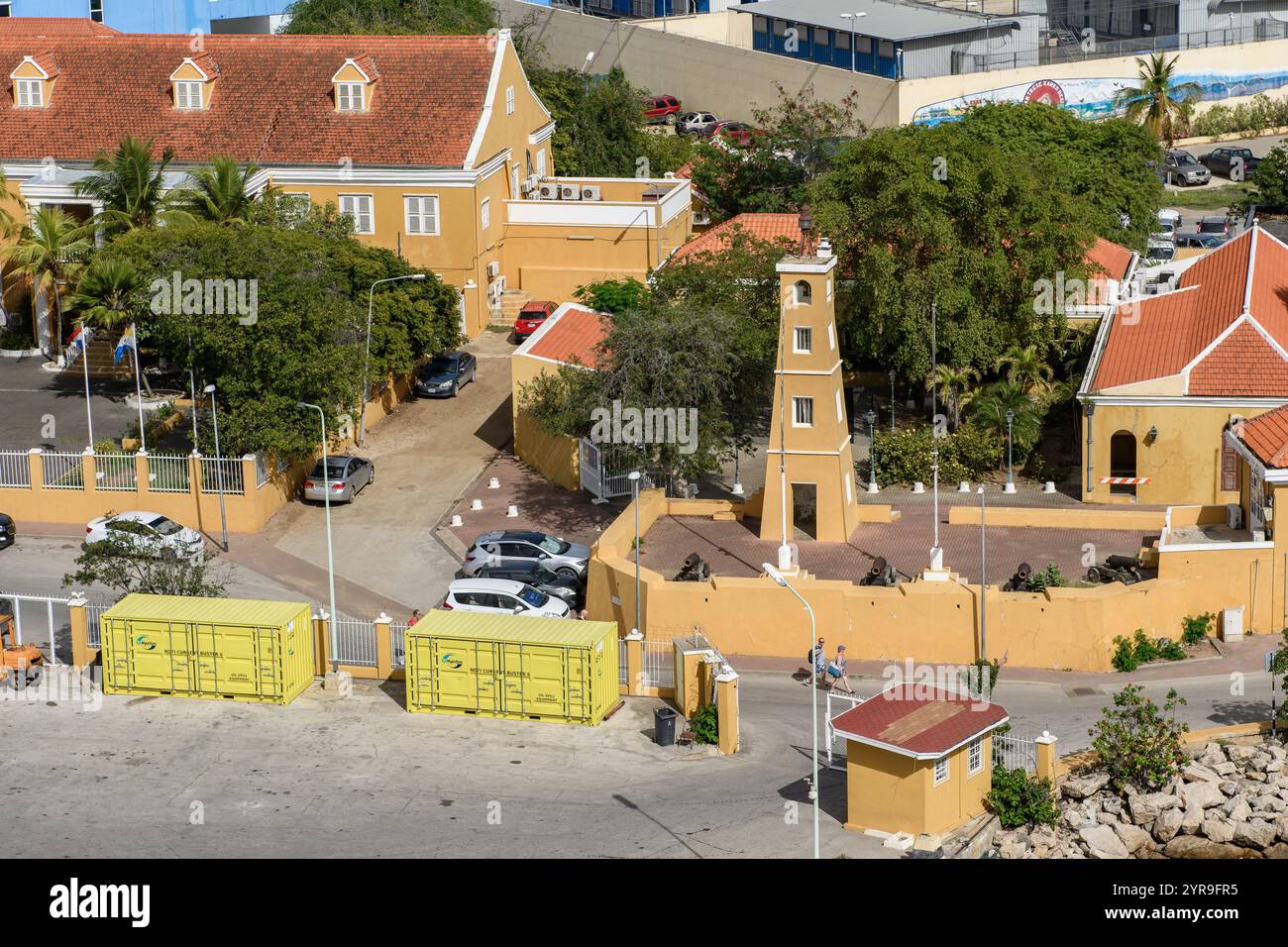 Kralendijk, Bonaire - January 5, 2018: A small medieval fortress now neighbors cars and bright shipping containers at the port. Stock Photo