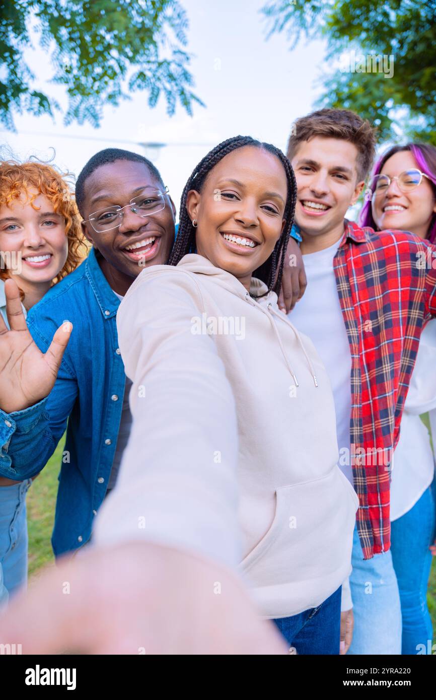 Happy diverse group of friends taking a selfie outdoors, smiling and ...