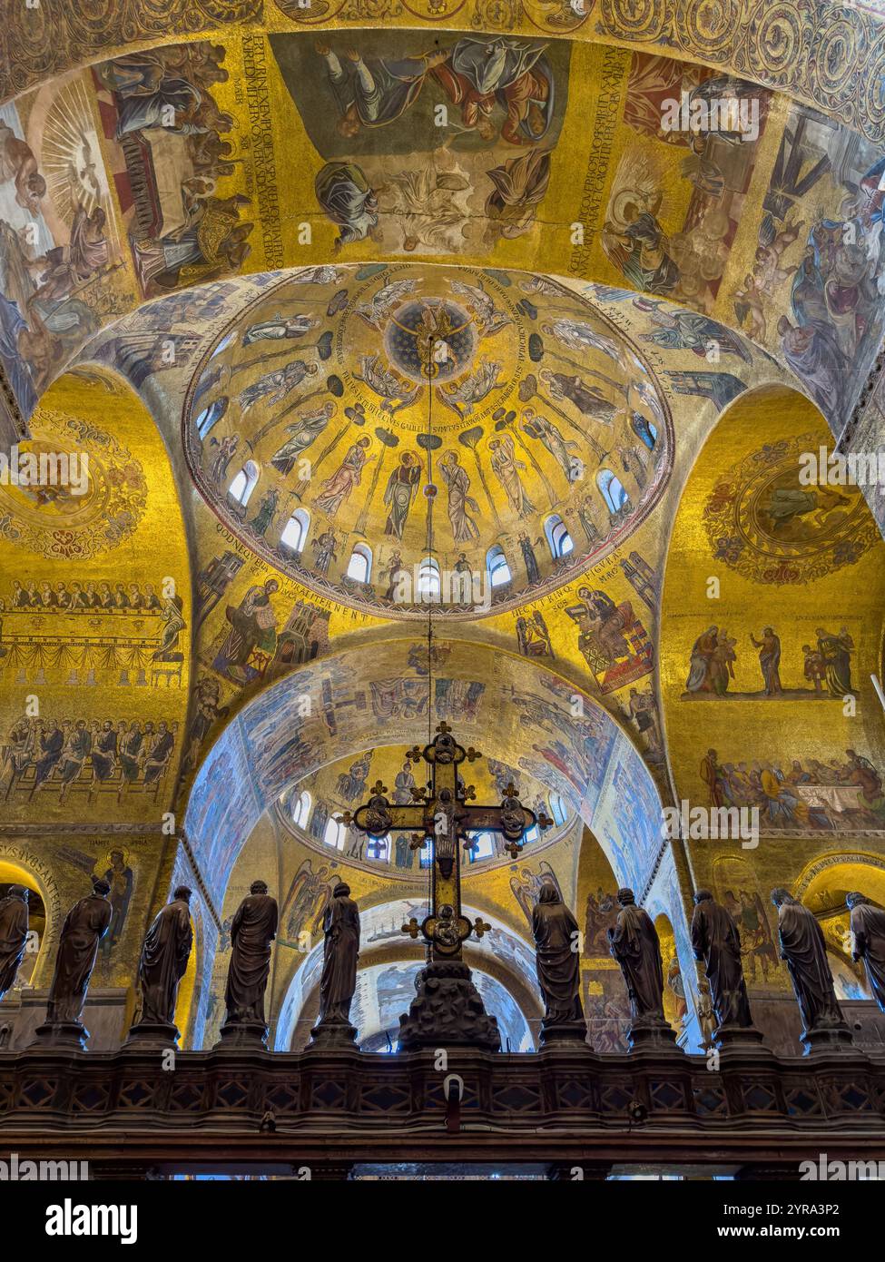 The silver and bronze crucifix on the Gothic altar screen in St. Mark's Basilica in Venice, Italy.  On either side are statues of the Virgin and the T Stock Photo