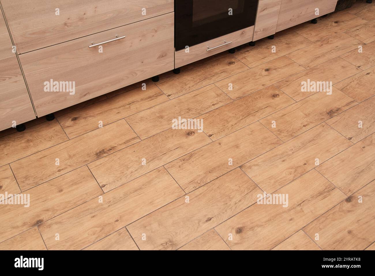 Empty place for carpet, mat or text. Top view. Ceramic Wood Floor Tiles on Kitchen, walnut ceramic floor. Beige Furniture at Kitchen. Stock Photo