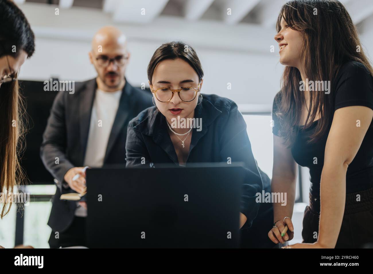 Students collaborating on a project with professor guidance Stock Photo