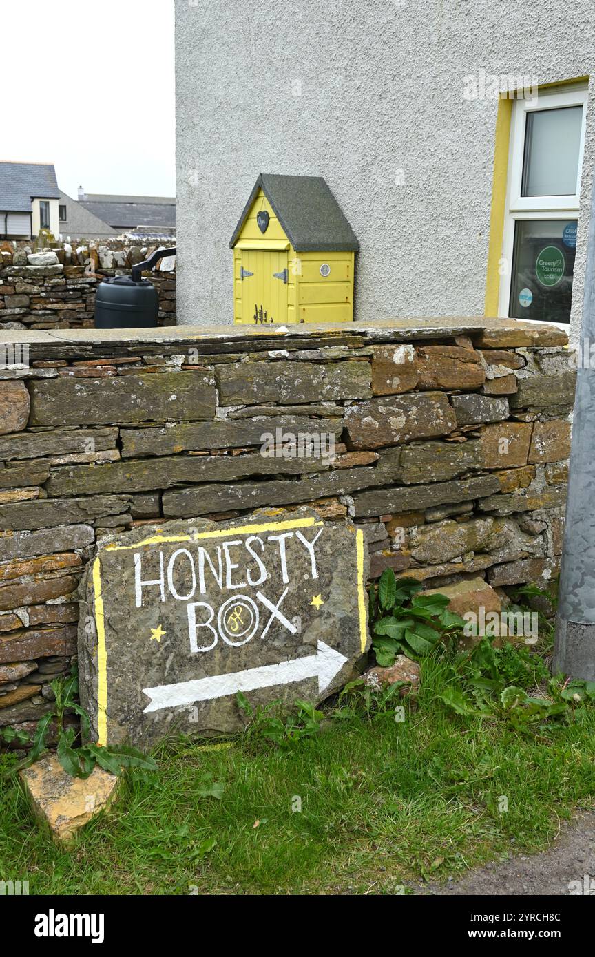 A sign to a yellow cake shed operating on an honesty box system in Orkney, Scotland Stock Photo
