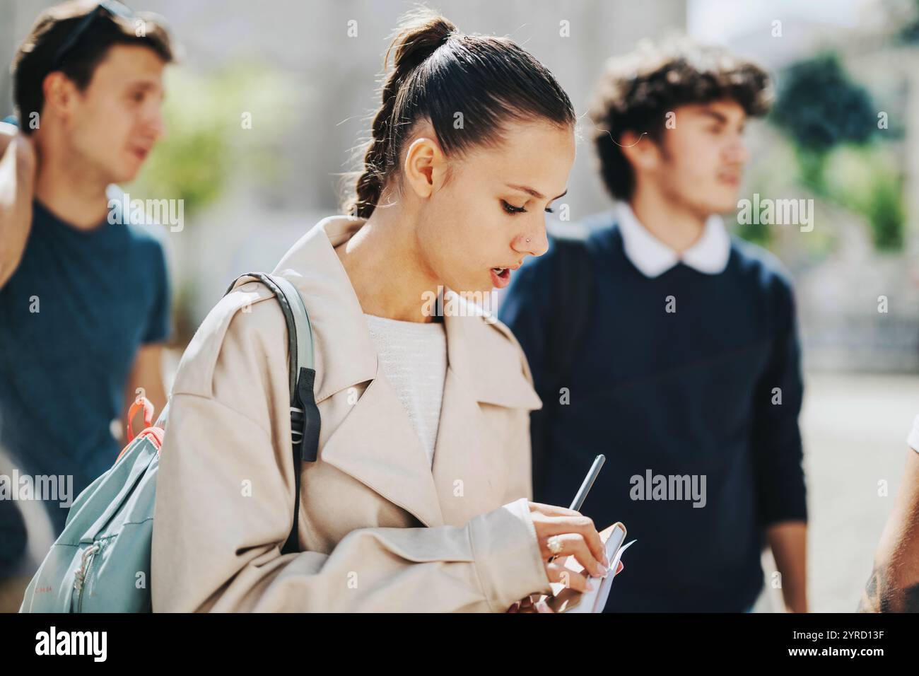 High school students collaborating outdoors with professor guidance Stock Photo