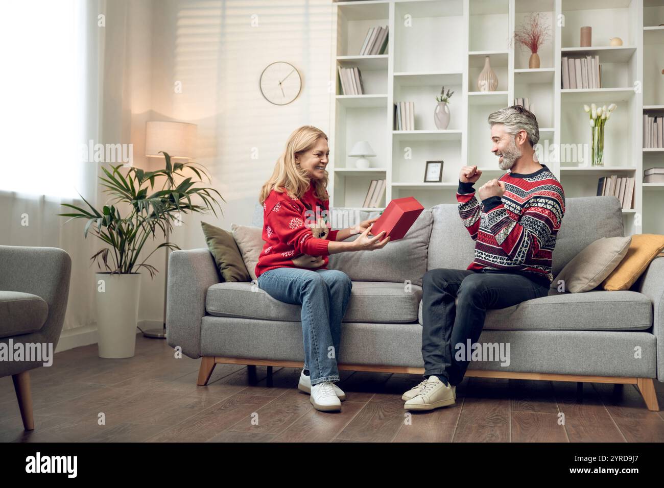 Happy couple exchanging presents for christmas and feeling enjoyed Stock Photo