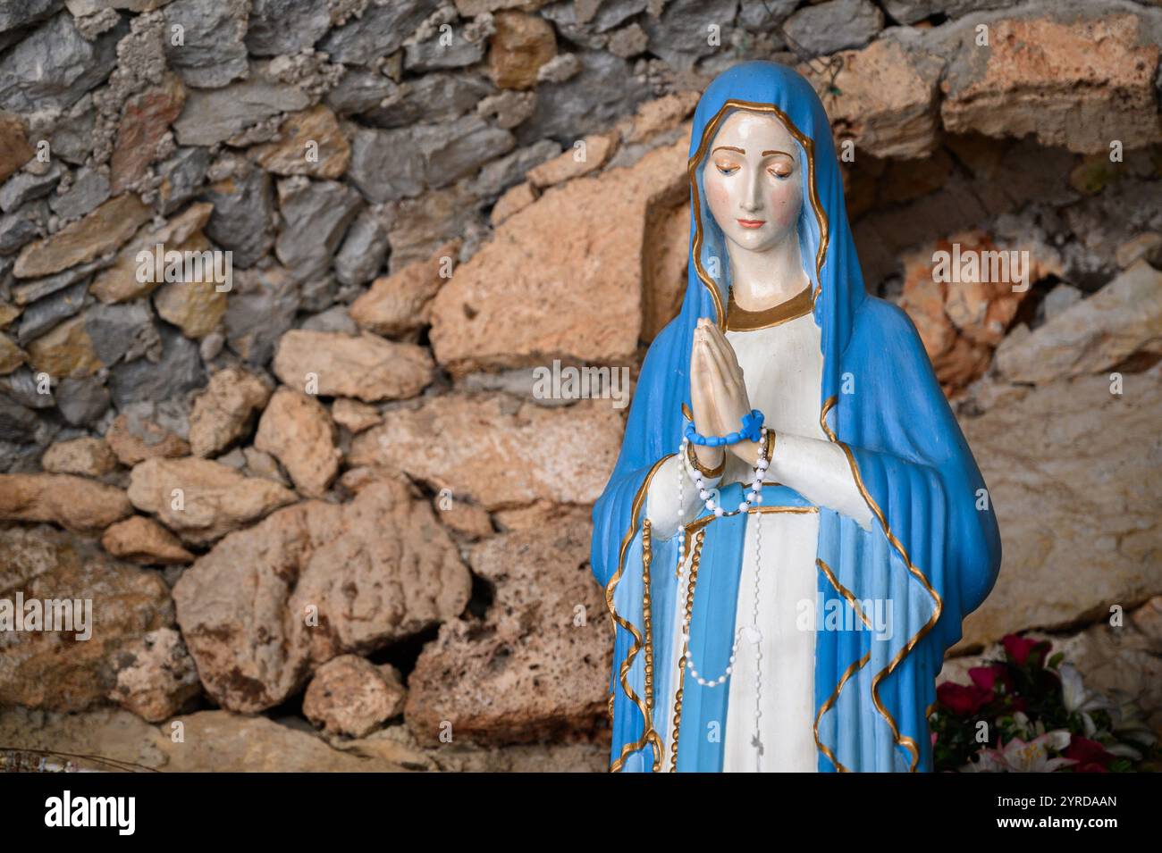 Our Lady of Lourdes – a statue in a grotto near the Church of the Sacred Heart of Jesus in Studenci, Bosnia and Herzegovina. Stock Photo
