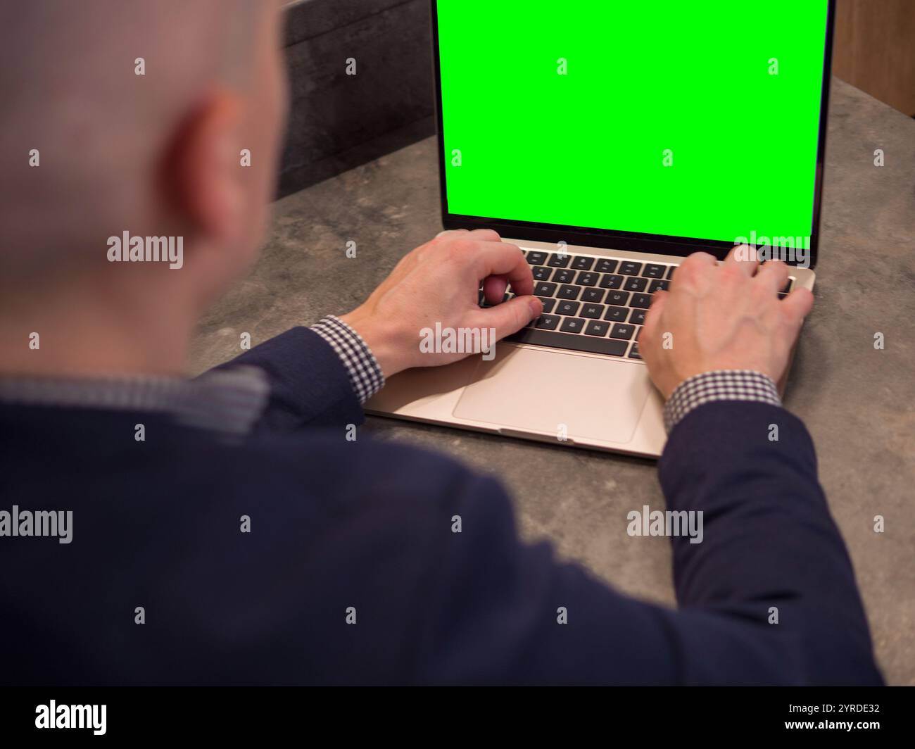 Business professional using laptop with dynamic green screen, ideal for versatile background in marketing and advertising Stock Photo
