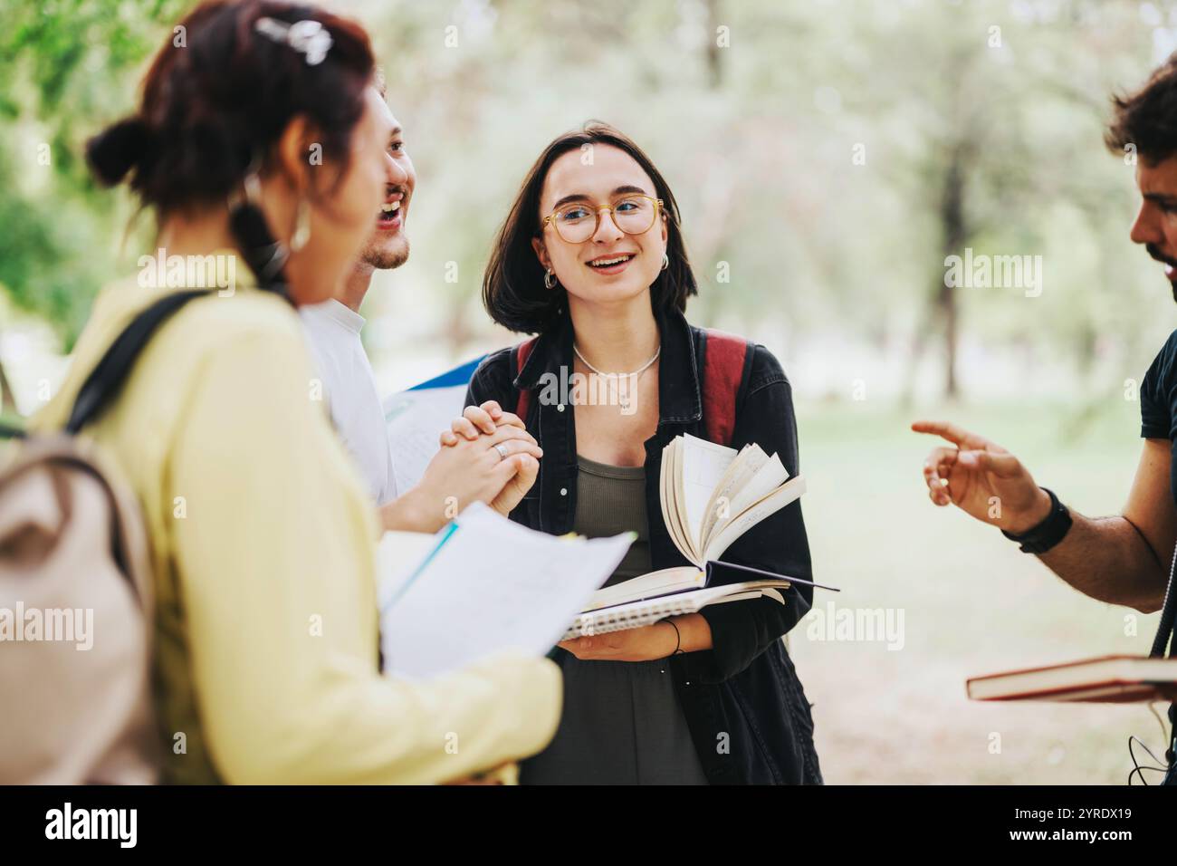 Multicultural students collaborating on school tasks in a park setting Stock Photo