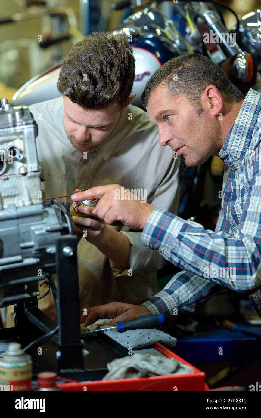 mechanicds repairing a motorbike engine in a mechanical workshop Stock ...