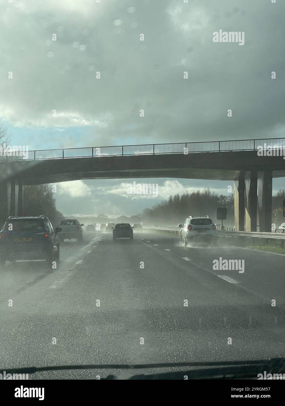 Difficult driving conditions of rain and strong sunshine travelling southbound on the M5 motorway, Somerset. UK - Smartphone Captured Stock Image
