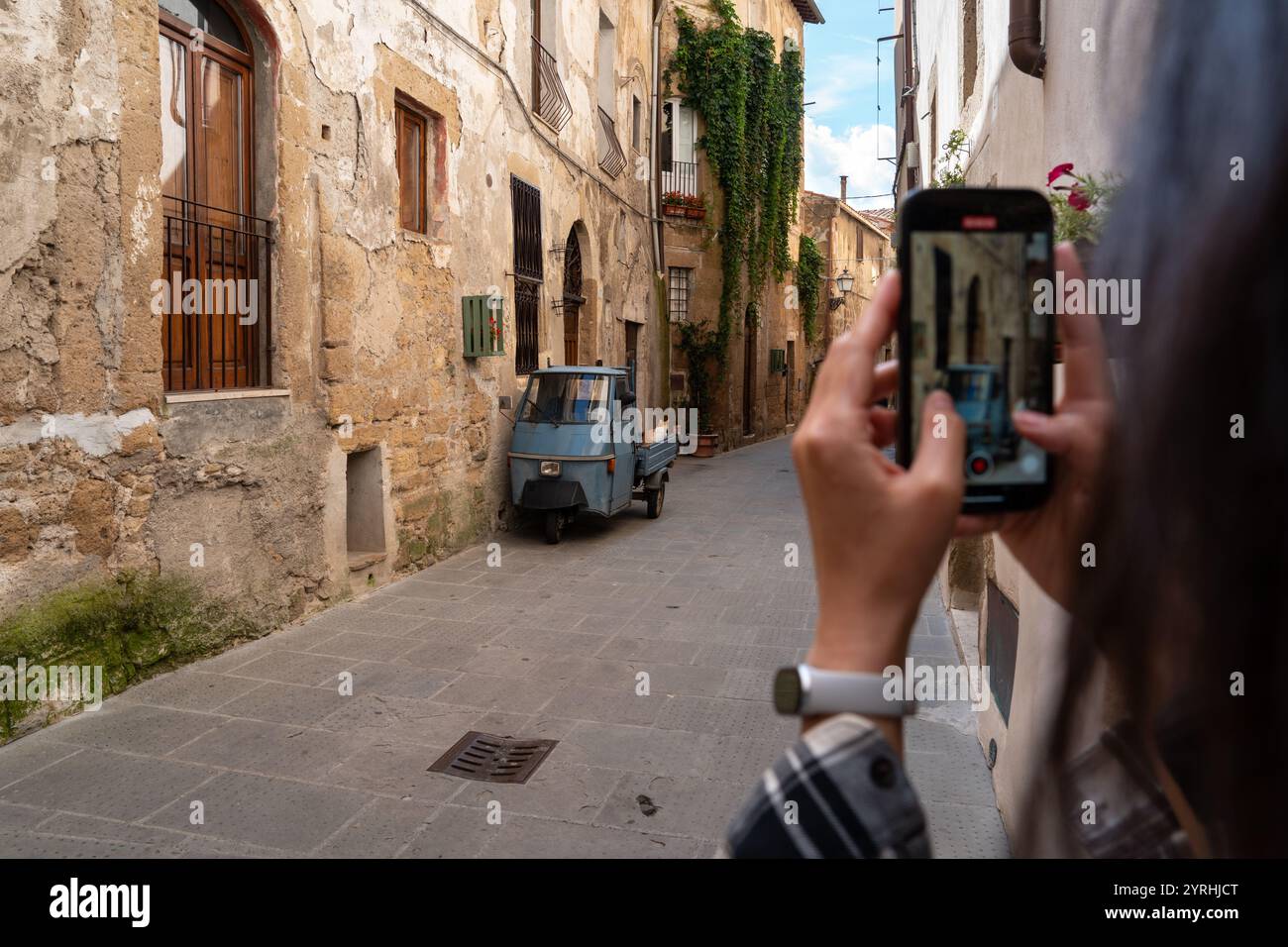 A person photographs a picturesque alley