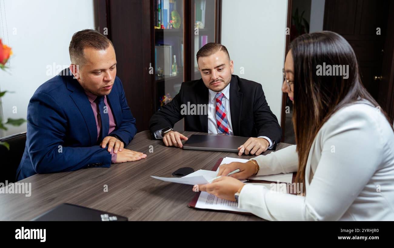 Three professionals review documents hi-res stock photography and ...