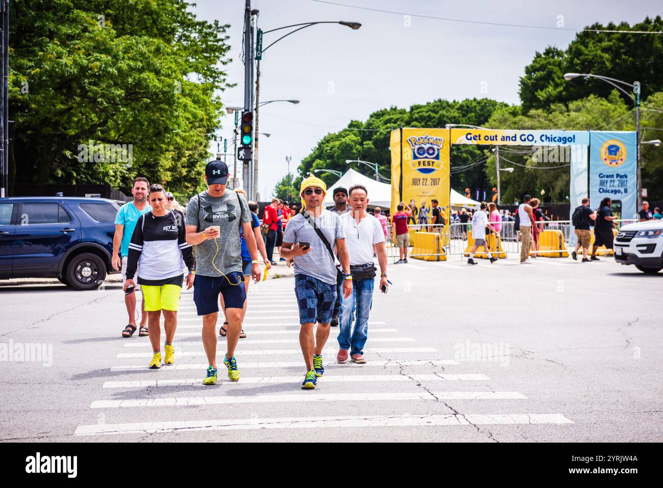 Chicago, IL USA - July 22, 2017: Pokemon GO players in crosswalk in front of Pokemon GO Fest sign. Stock Photo
