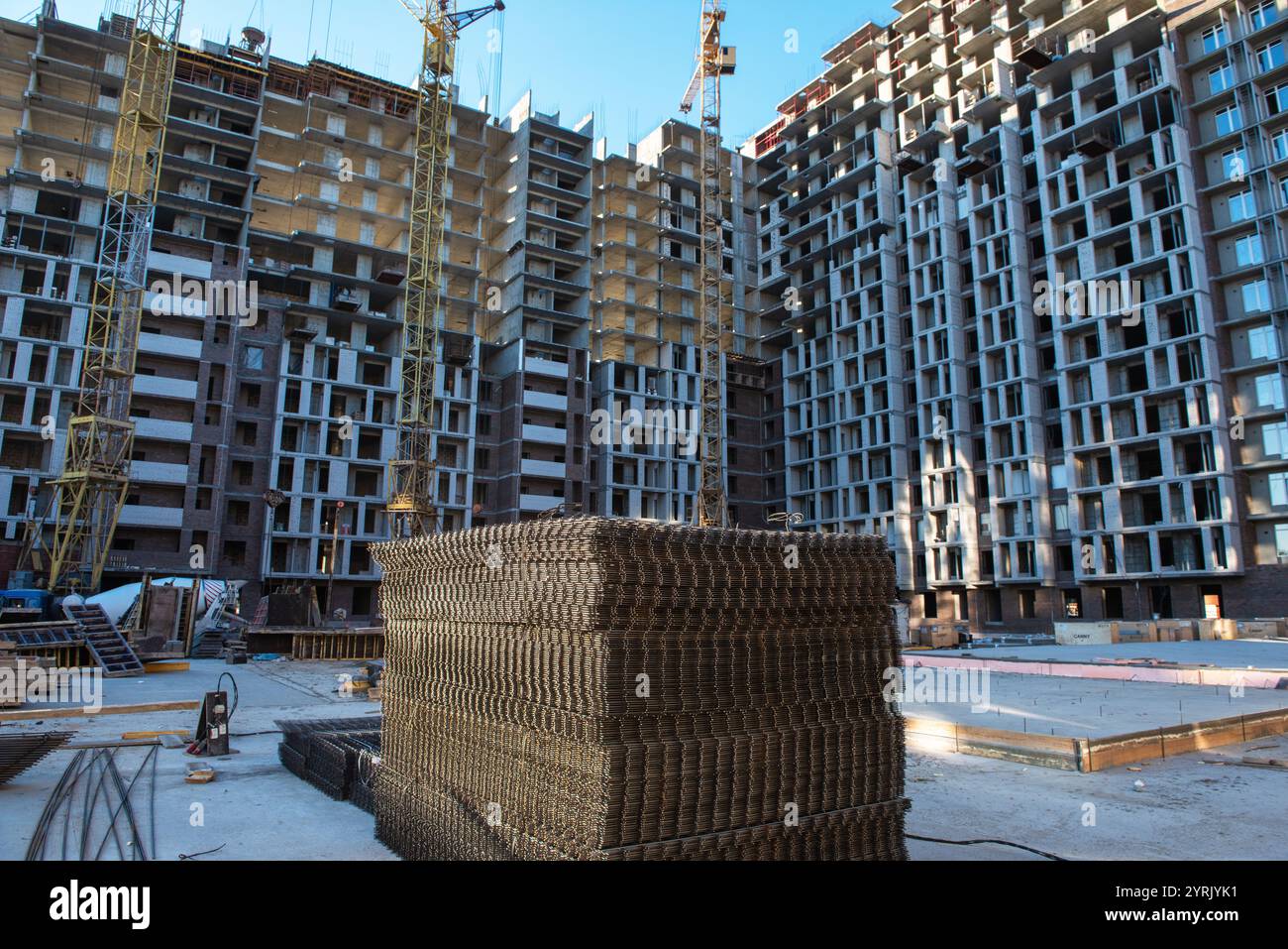 Picture of Ongoing construction of modern high-rise apartments with cranes, steel ...