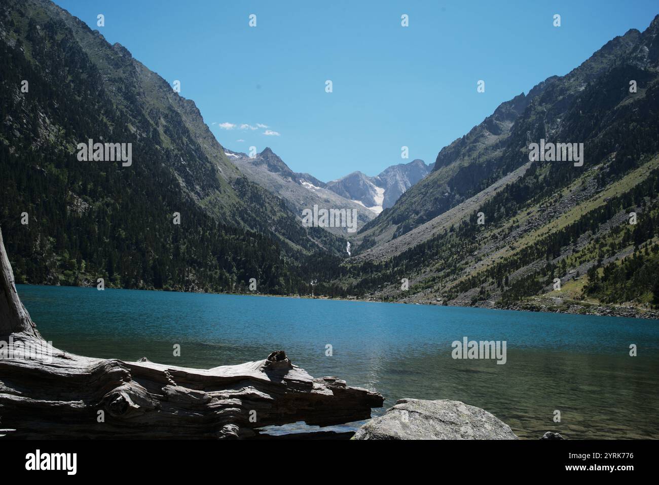lake Gaube framed by rugged, forested mountain peaks in Pyrenees France Stock Photo