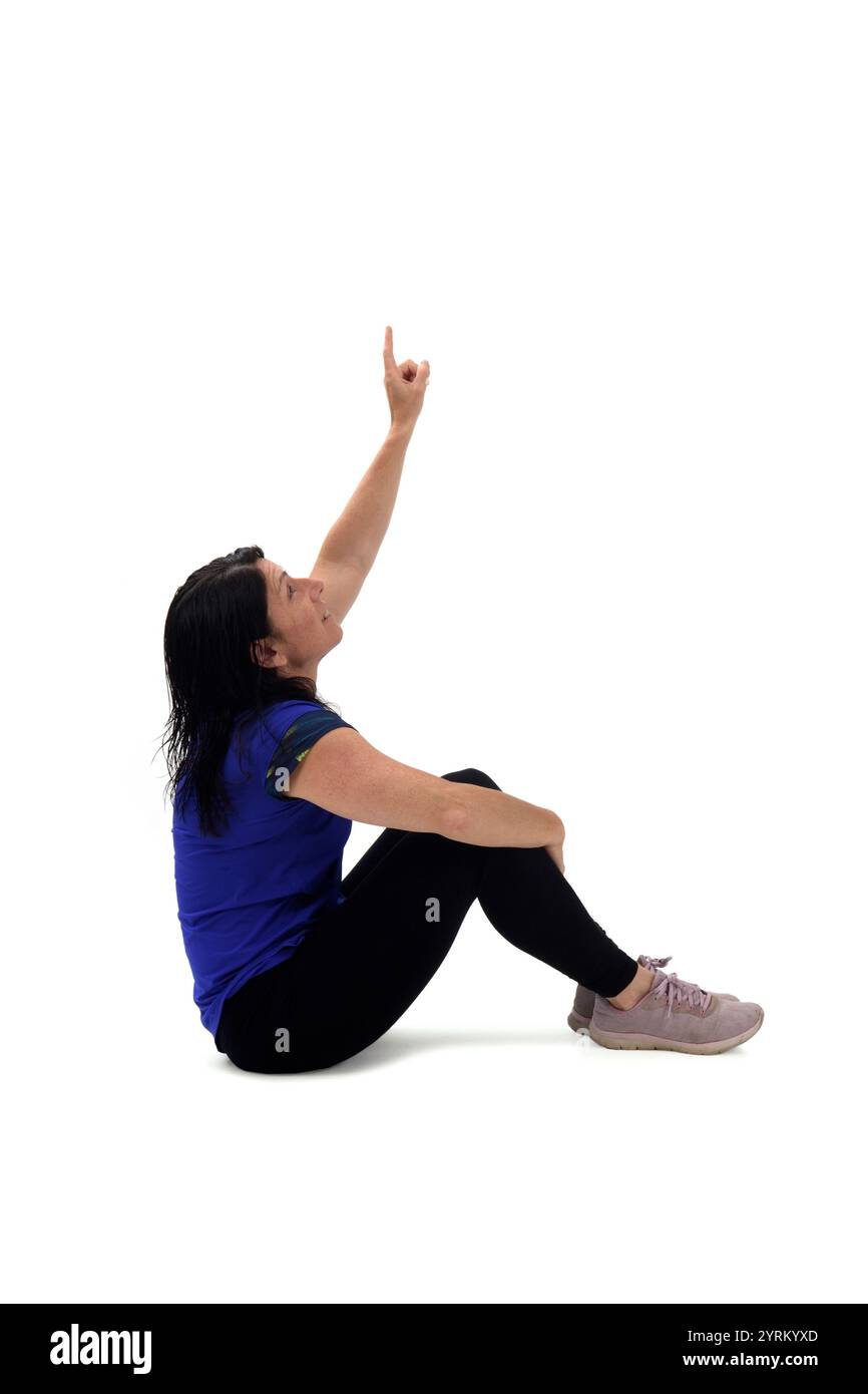 side view of a woman sitting on the floor looking and pointing finger ...
