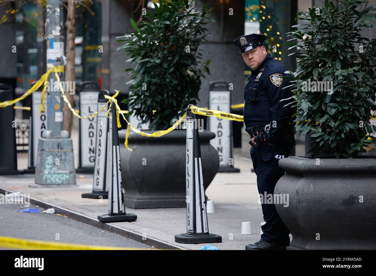 A New York police officer stands outside the Hilton Hotel in midtown ...