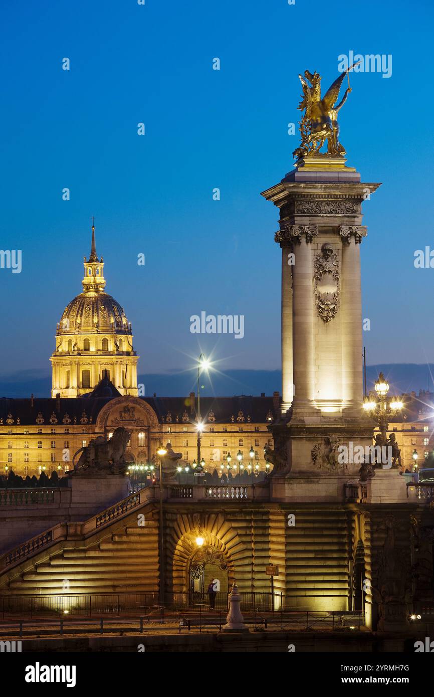 Pont Alexandre III bridge towards Hotel des Invalides and Eglise du Dome at dusk, Paris, France Stock Photo