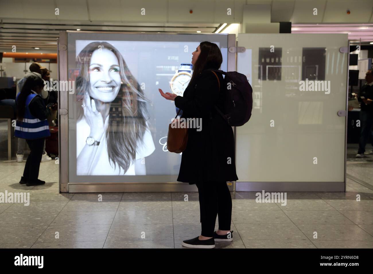 woman-looking-at-flight-times-on-information-board-at-heathrow-airport