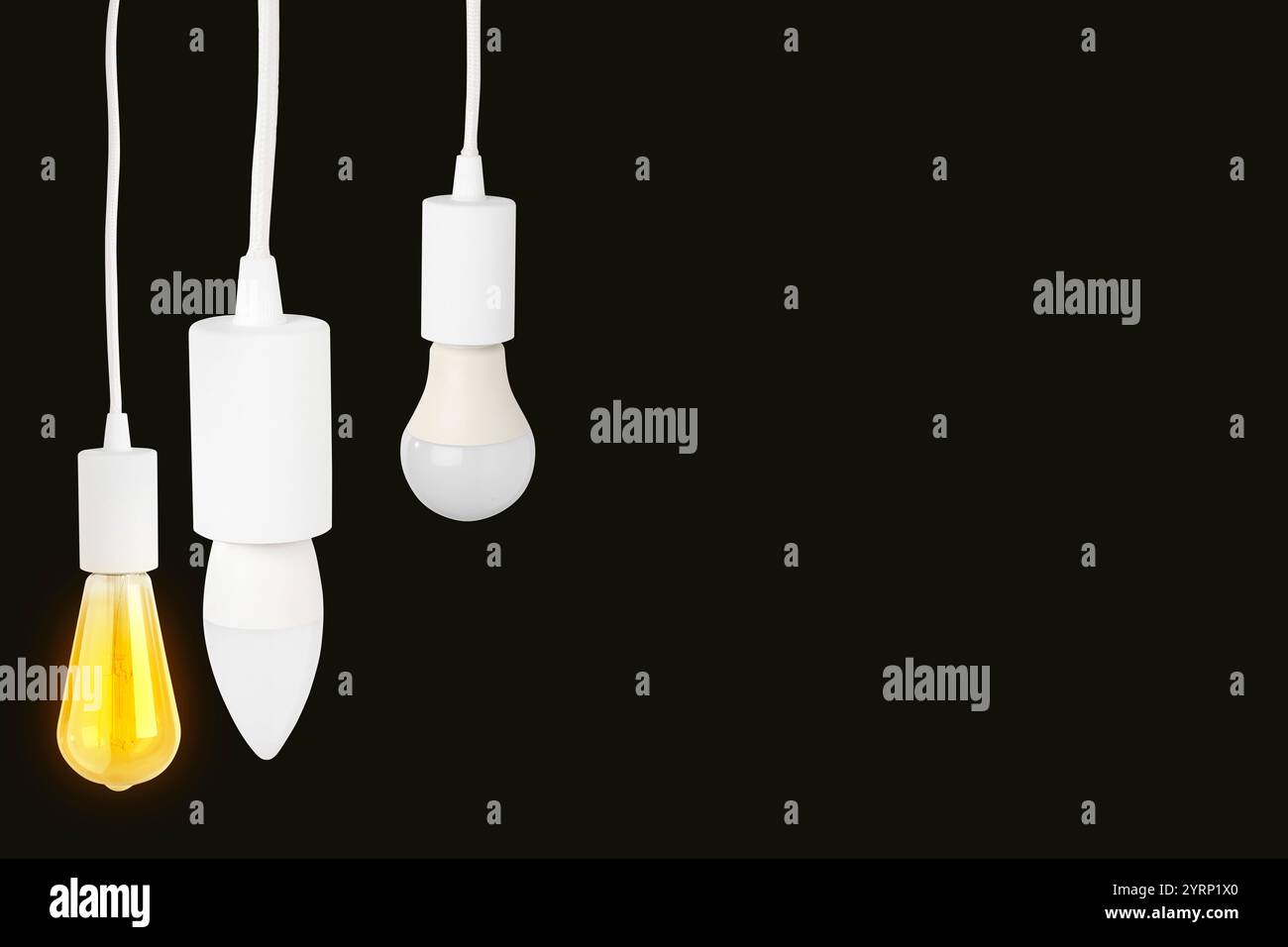 Different light bulbs hanging on black background. Space for text Stock Photo