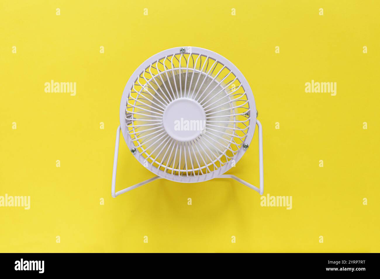 Metal mini fan on a yellow background. Heat and ventilation Stock Photo