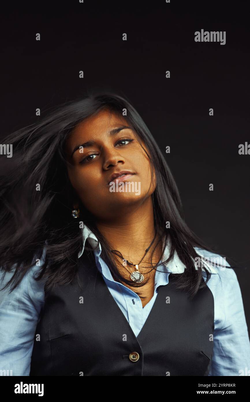 Confident young indian woman with long, dark hair blowing around her ...