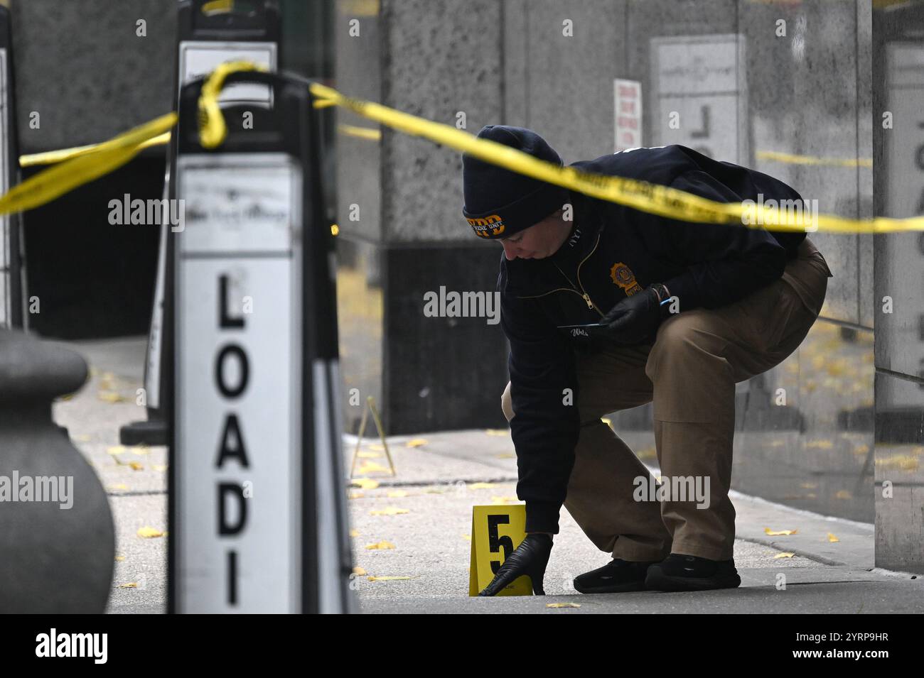 New York, USA. 04th Dec, 2024. A member of the NYPD steps near a shell ...