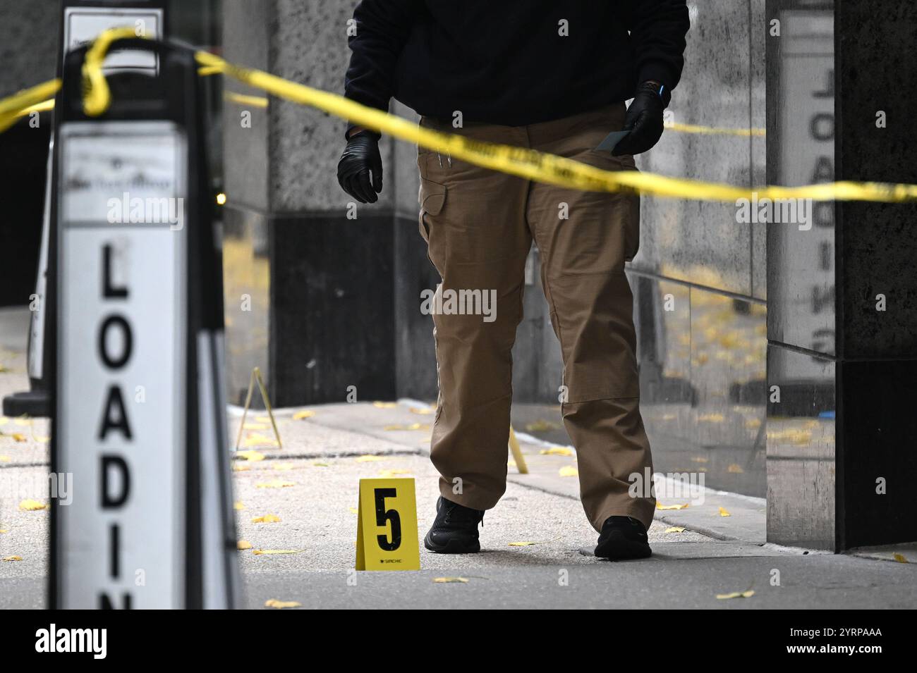New York, USA. 04th Dec, 2024. A member of the NYPD steps near a shell ...