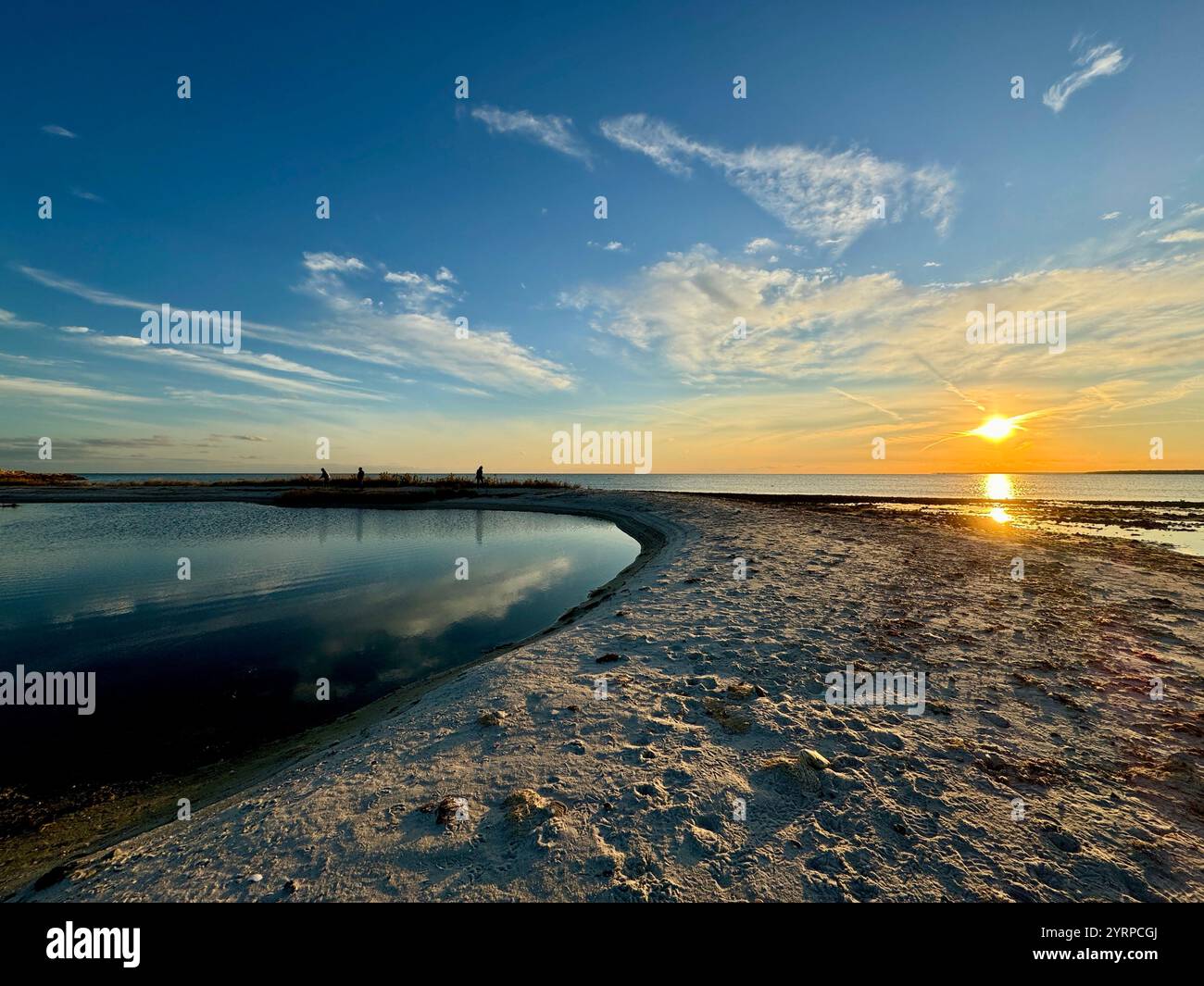 A breathtaking sunset over Cape Cod, casting vibrant hues across the sky and reflecting on tranquil waters, capturing nature's beauty. - Smartphone Captured Stock Image