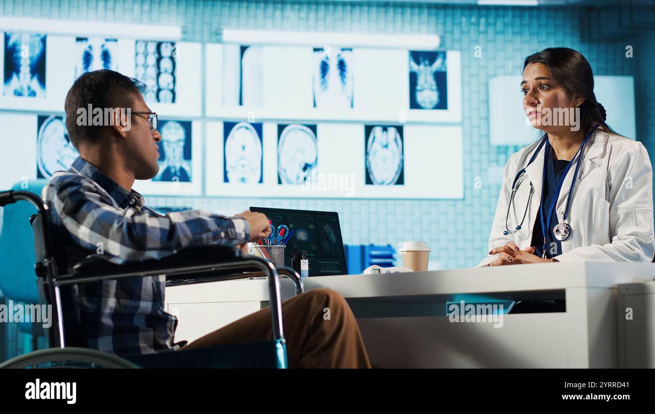 Indian male patient with chronic disability discussing with a medic in ...