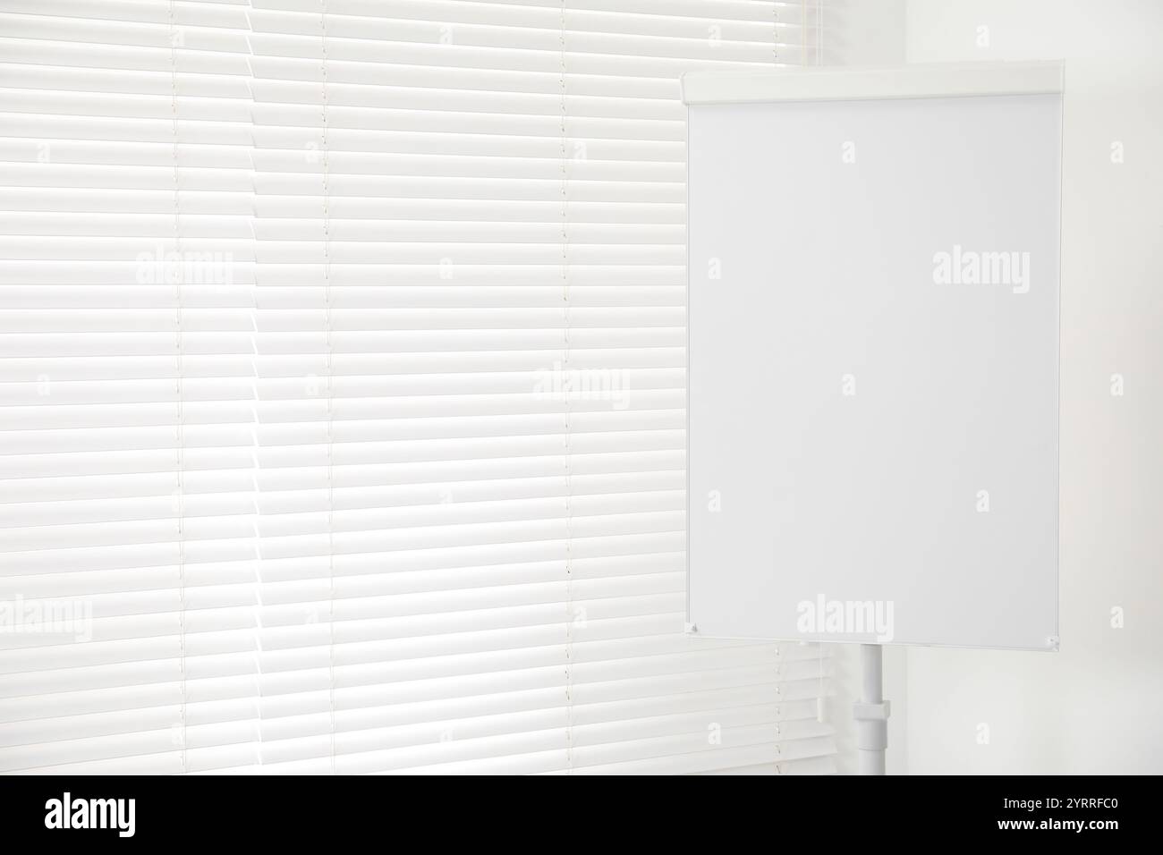 Flip chart near window in office. Mockup for design Stock Photo Alamy