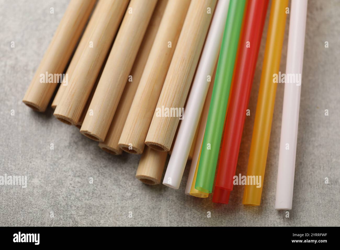 Different drinking straws on grey table, closeup Stock Photo