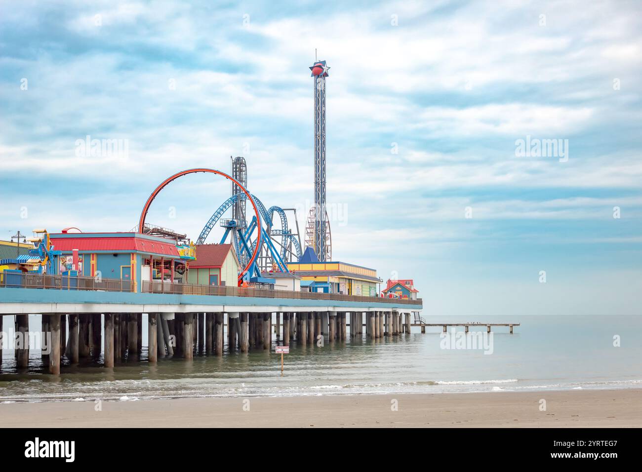 Amusement park boardwalk and carnival rides along the beach. Photo ...