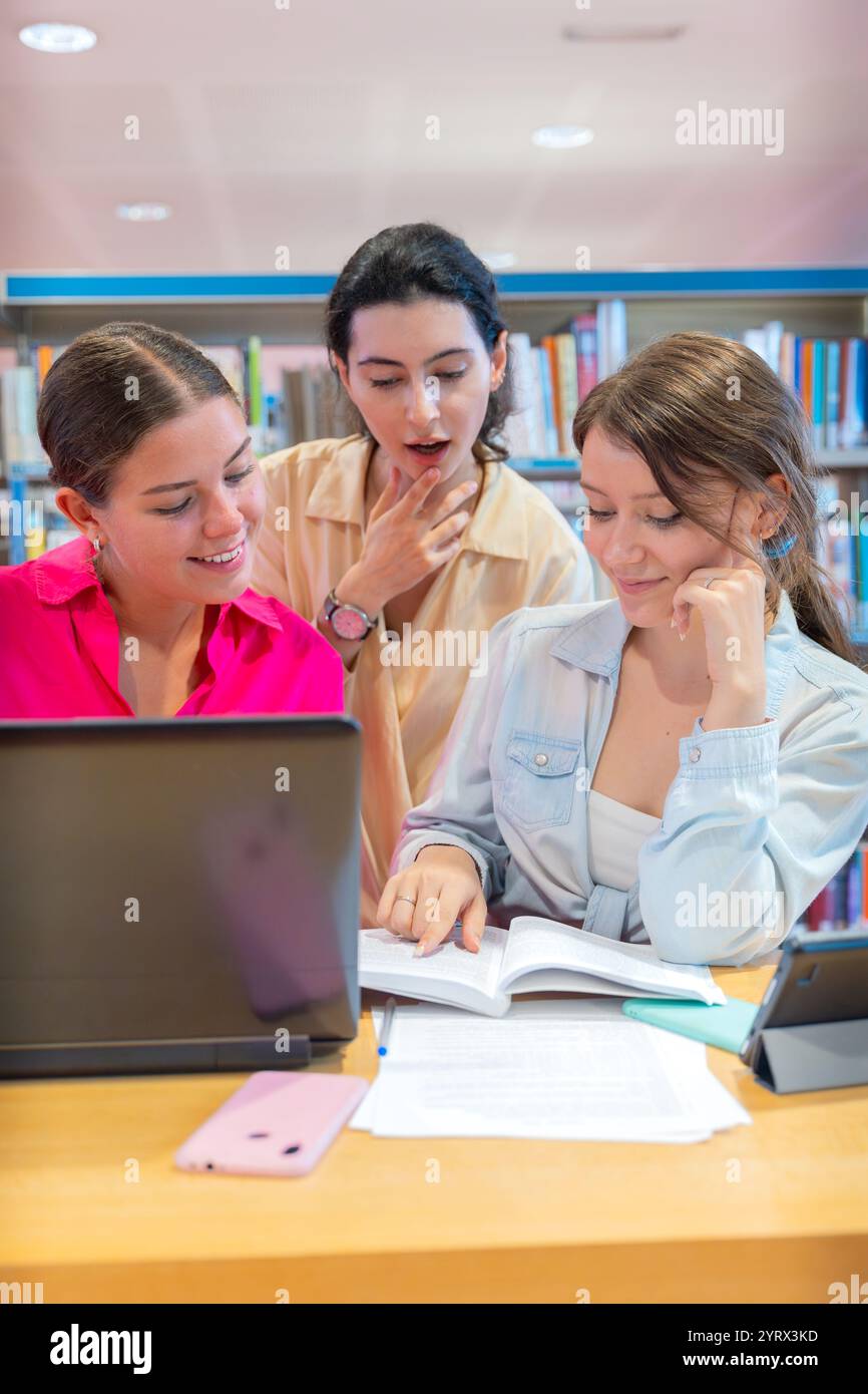 Group of students collaborating on a project in a library.Vertical Stock Photo