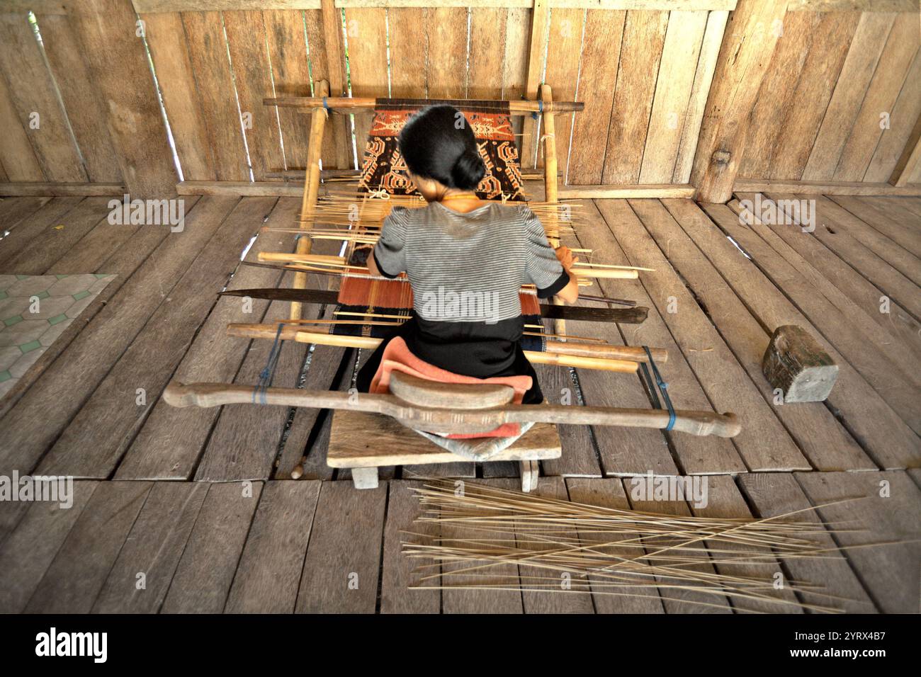 A woman weaving traditional woven fabric in traditional village of ...
