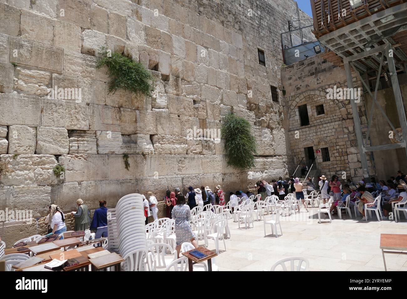 Jews pray at the Western Wall, (Wailing Wall, or Kotel), an ancient limestone wall in the Old City of Jerusalem. It is a relatively small segment of a far longer ancient retaining wall. The wall was originally erected as part of the expansion of the Second Jewish Temple begun by Herod the Great, Stock Photo