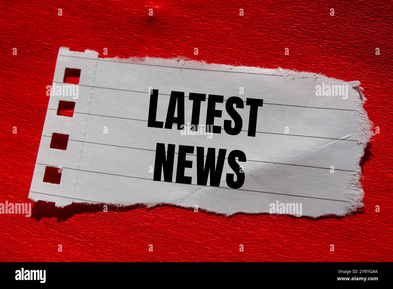 Latest news message written on ripped torn paper piece with red ...