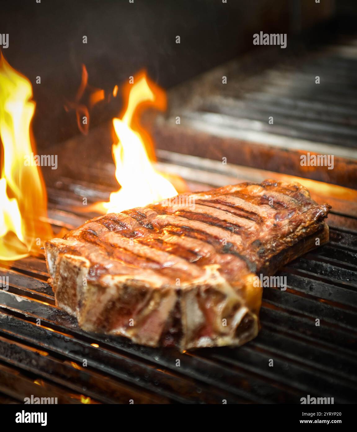 Close up of a grilled beef steak on a barbecue grill with flames Stock ...