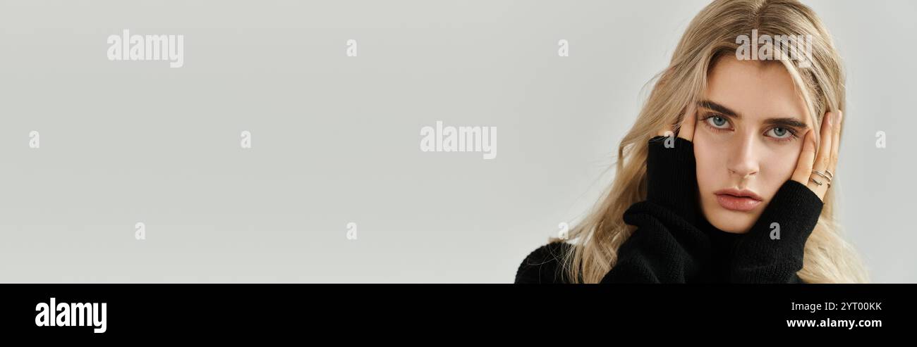 A young woman with long blonde hair poses elegantly in a stylish outfit ...