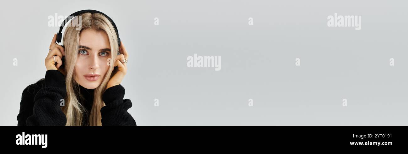 Young woman with long blonde hair poses elegantly in dark attire ...