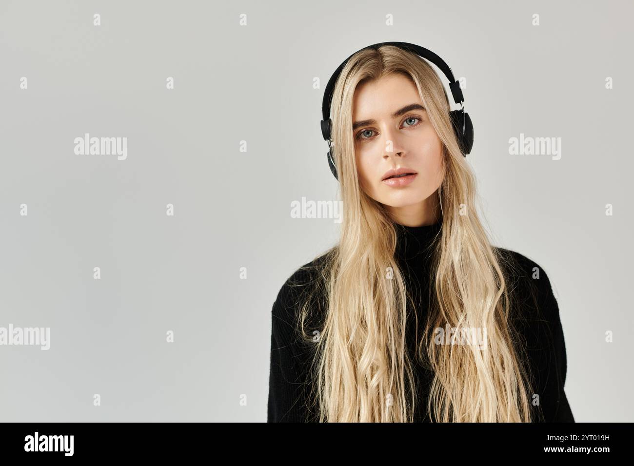 Young woman with long blonde hair poses elegantly in a black outfit ...